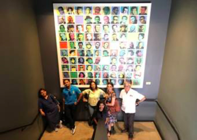 Brand USA India Global Office members standing under a poster of music legends