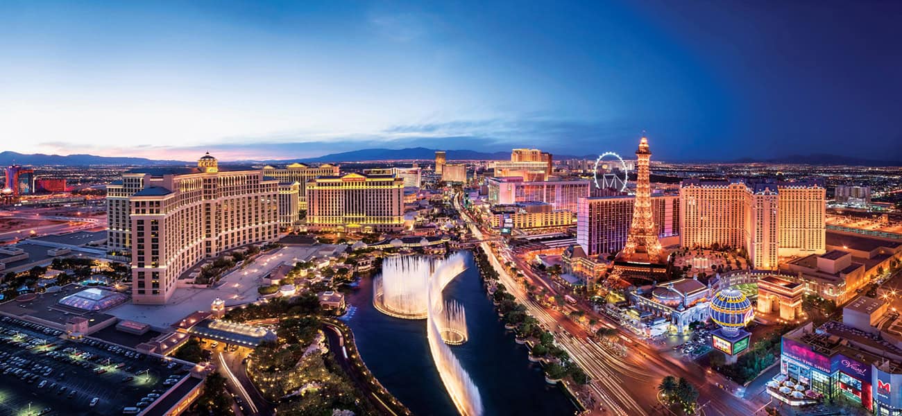 Night view of Las Vegas Strip with illuminated hotels and attractions.