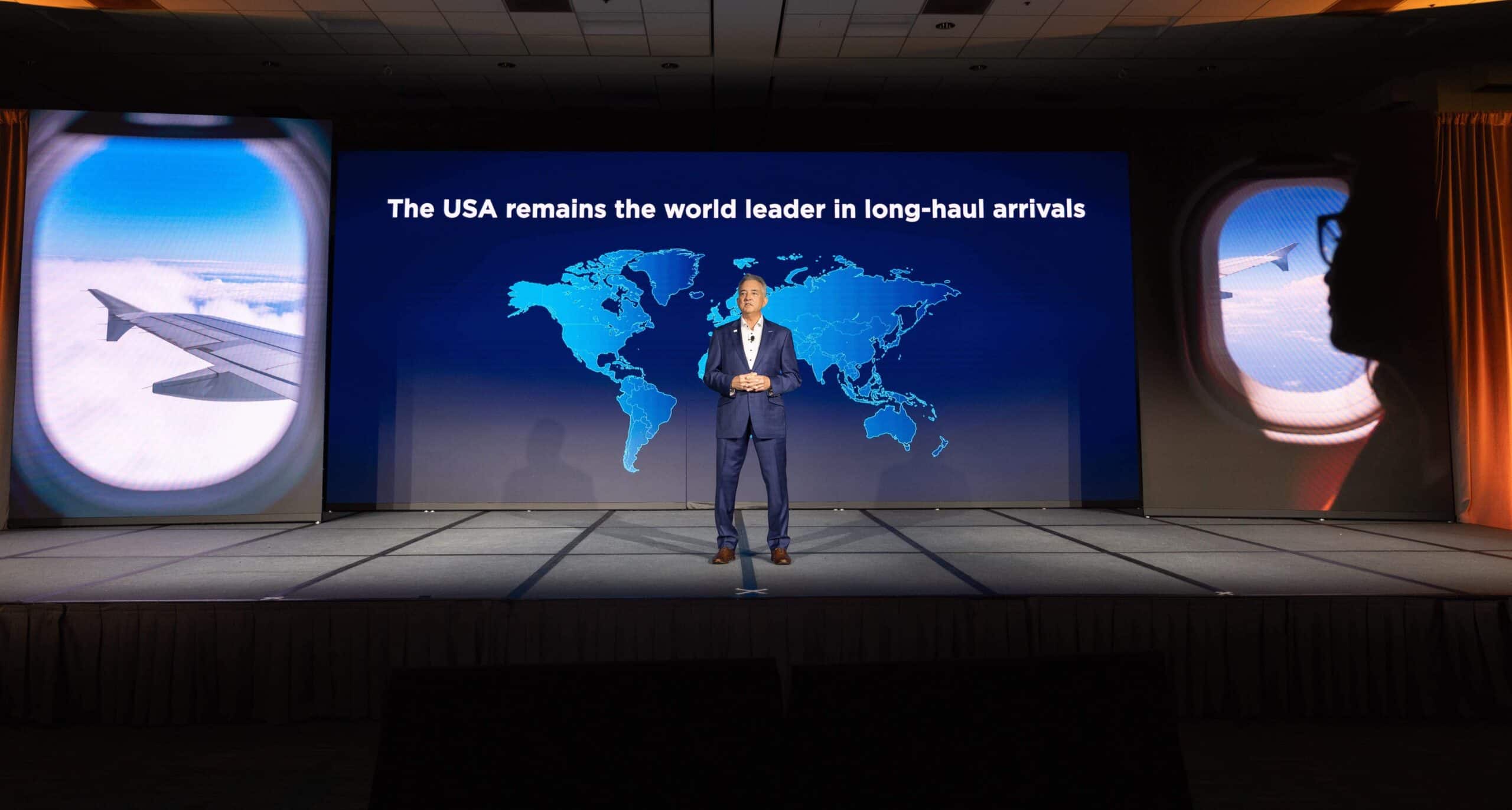 Speaker presenting on USA's global travel leadership at conference.
