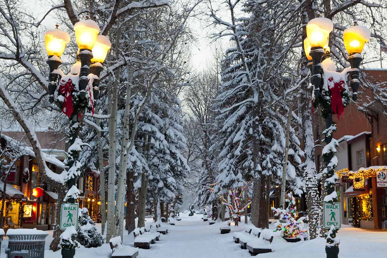 Snow-covered street with festive lights and Christmas decorations in the USA.